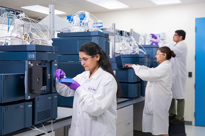 Laboratory scientists conducting pharmaceutical research using analytical instruments in a modern laboratory.